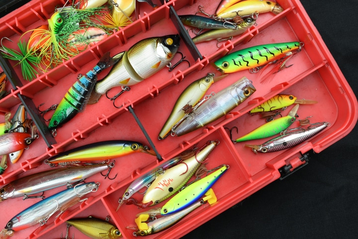 An assortment of fishing lures in a tackle box.